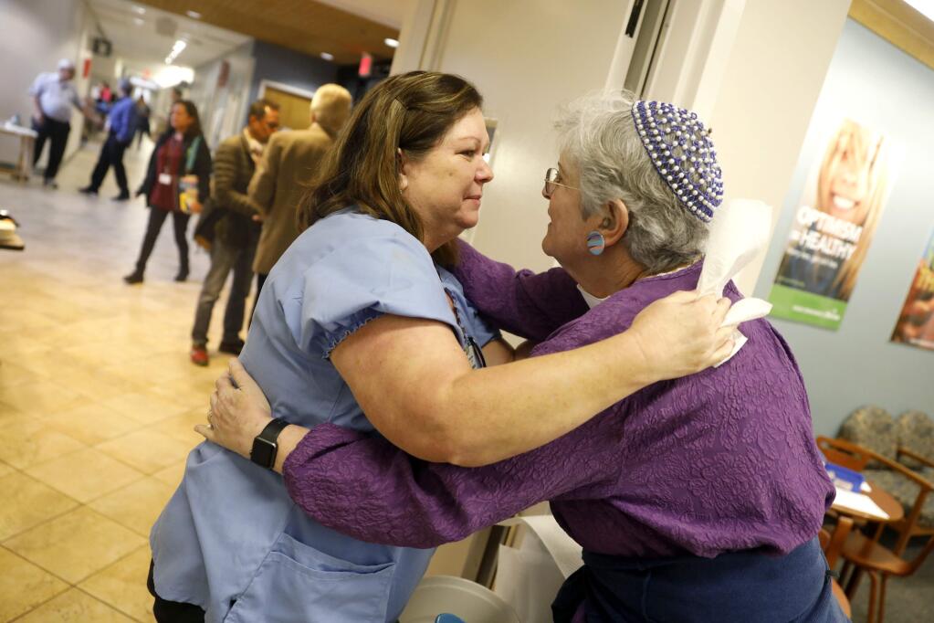 Pediatric LVN Shelly Matthews receives gets a hug from chaplain Meredith Cahn as Kaiser Permanente reopens its medical clinics in Santa Rosa, on Monday, October 16, 2017. (BETH SCHLANKER/ The Press Democrat)