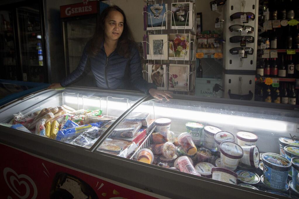 Glen Ellen Grocery proprietor Sonia Baweja,had to deal with the power outage still in effect on Sunday morning, Oct. 27, Using only one small generator for the cold cases, she feared for the long-term effect on her business. (Photo by Robbi Pengelly/Index-Tribune)