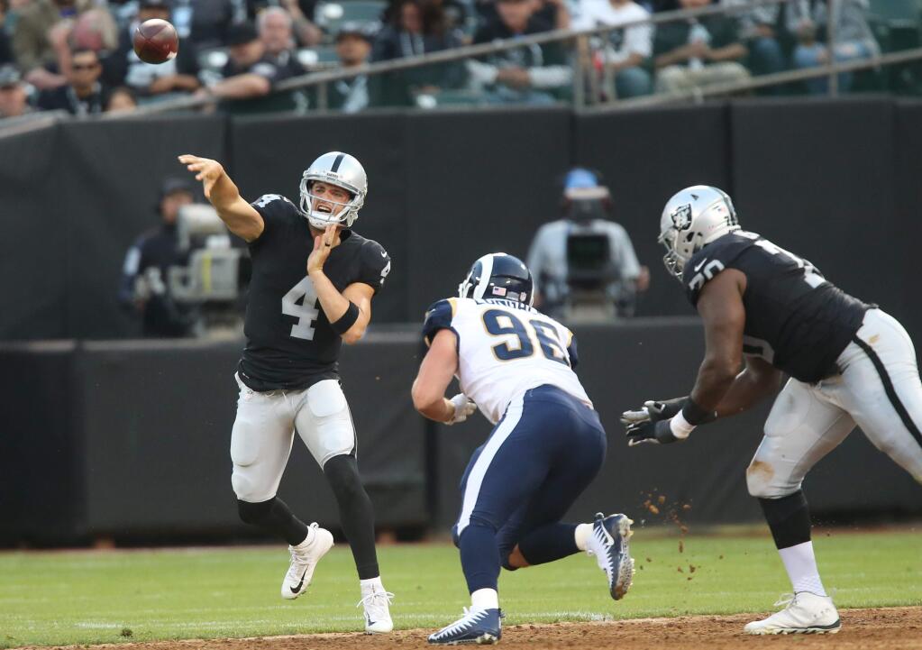 Oakland Raiders quarterback Derek Carr passes the ball against the Los Angeles Rams, in Oakland on Saturday, August 19, 2017. (Christopher Chung / The Press Democrat)