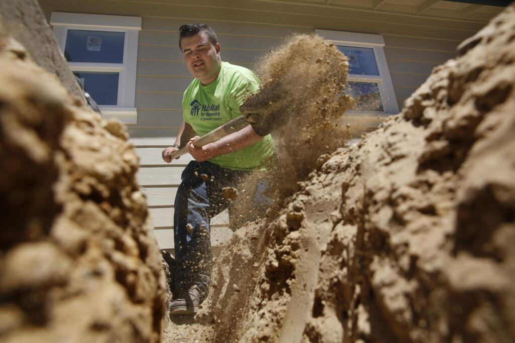 Mateo Swaim-Brouwer, a resident of Sanctuary House, digs a trench for a pipe to be laid outside a Habitat for Humanity home under construction on Tuesday, July 26, 2016 in Cotati, California . (BETH SCHLANKER/ The Press Democrat)