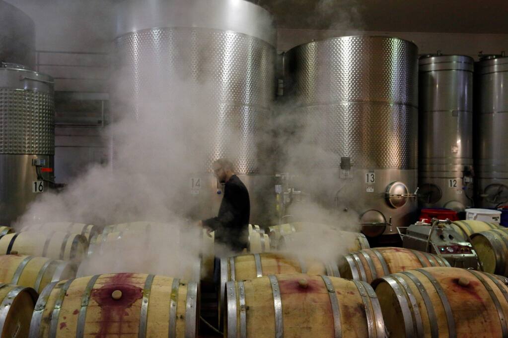 Associate winemaker Ross Reedy works on steaming French oak barrels to sanitize them for reuse at VML Winery in Healdsburg, California on Thursday, December 3, 2015. Truett-Hurst and former partner Bill Hambrecht are currently in a legal dispute over whether the winery can still lease the Westside Road property where its sister winery, VML, and 25 percent of its wine production are housed. (Alvin Jornada / The Press Democrat)