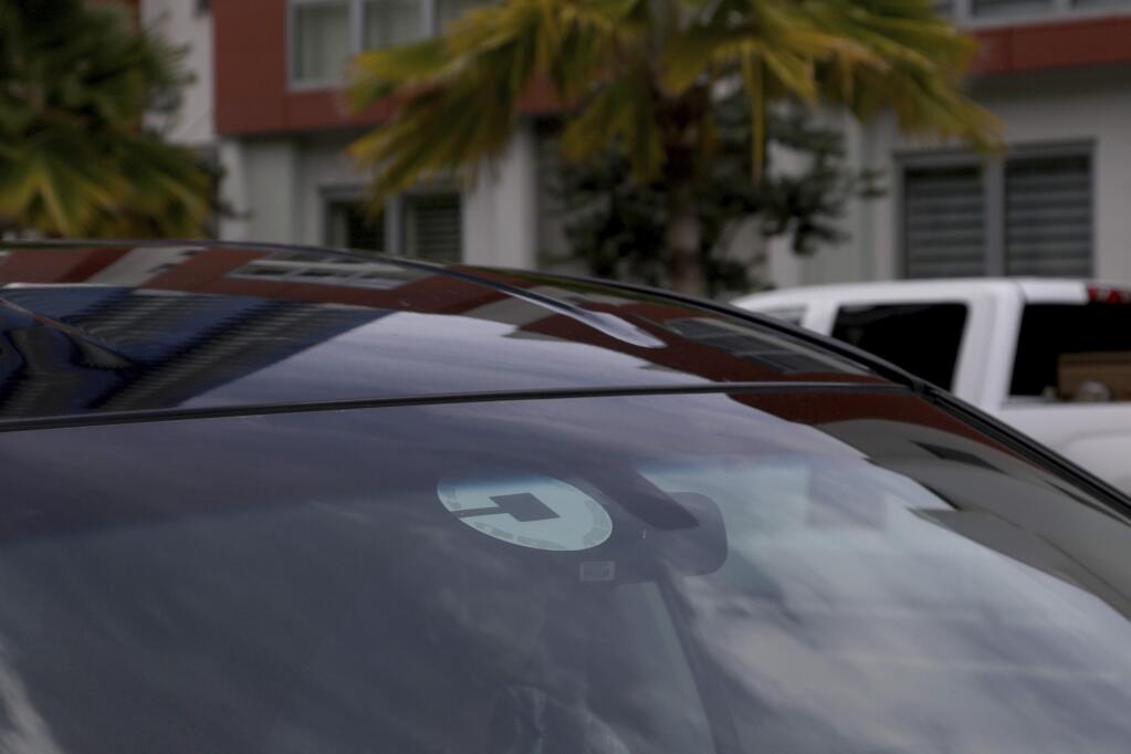 FILE- In this June 6, 2018, file photo Uber driver Joshua Oh drives in Honolulu. (AP Photo/Caleb Jones, File)