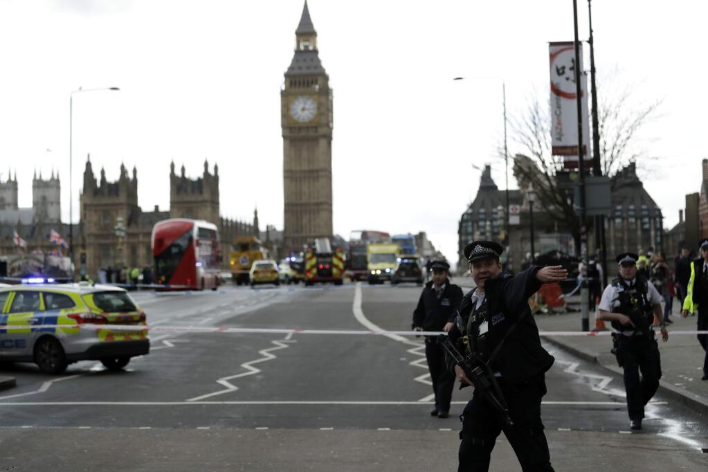 Police secure the area on the south side of Westminster Bridge close to the Houses of Parliament in London, Wednesday, March 22, 2017. The leader of Britain's House of Commons says a man has been shot by police at Parliament. David Liddington also said there were 'reports of further violent incidents in the vicinity.' London's police said officers had been called to a firearms incident on Westminster Bridge, near the parliament. Britain's MI5 says it is too early to say if the incident is terror-related. (AP Photo/Matt Dunham)