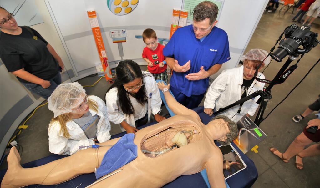 Ashlynn Dexter, 10 and Dafne Cruz, 15 learn how the human heart works from Craig Murphy (in blue). A free event for kids, the North Bay Discovery Day event gets kids excited about careers in science, technology, engineering and math, Sonoma County Event Center, Saturday October 27th, 2018. (WILL BUCQUOY/ For the PD).
