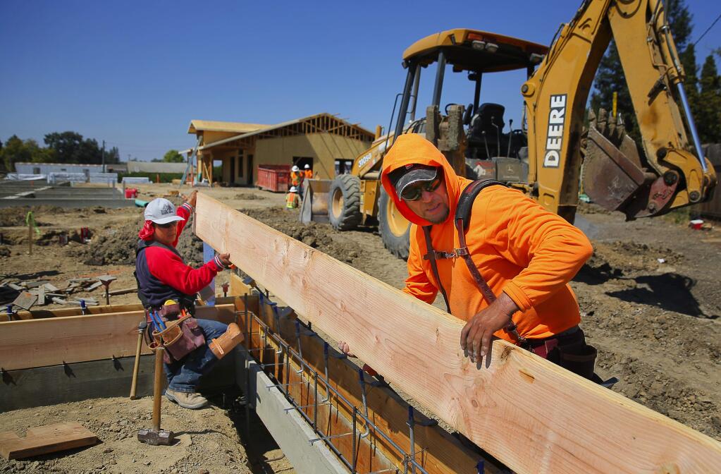 Jesus Angel, left, and Manuel Guzman work on the Ortiz Family Plaza, which will include 30 affordable housing units, in the Larkfield area, on Tuesday, September 6, 2016. (Christopher Chung/ The Press Democrat)