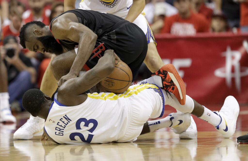 Houston Rockets guard James Harden, top, battles Golden State Warriors forward Draymond Green for a loose ball during the first half in Game 5 of the NBA basketball playoffsWestern Conference finals in Houston, Thursday, May 24, 2018. (AP Photo/David J. Phillip)