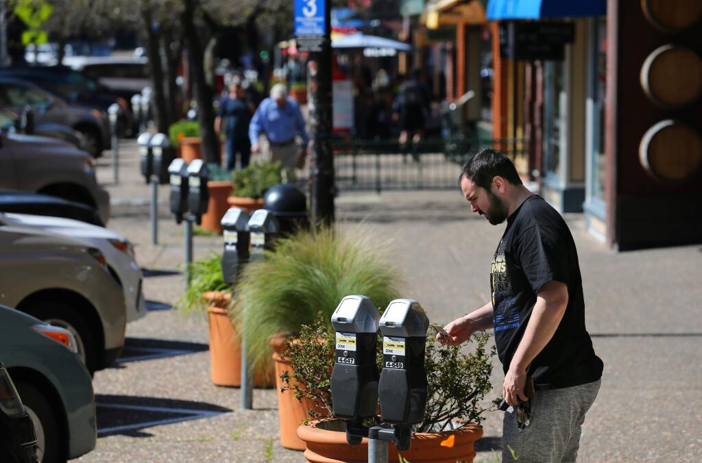 Spencer G. of Santa Rosa pays for parking on Fourth St. in Santa Rosa on Monday, March 18, 2019. (BETH SCHLANKER/ The Press Democrat)