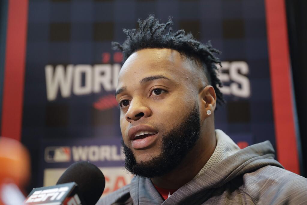 Cleveland Indians designated hitter Carlos Santana talks during media day for baseball's upcoming World Series against the Chicago Cubs on Monday, Oct. 24, 2016 in Cleveland. (AP Photo/Charlie Riedel)