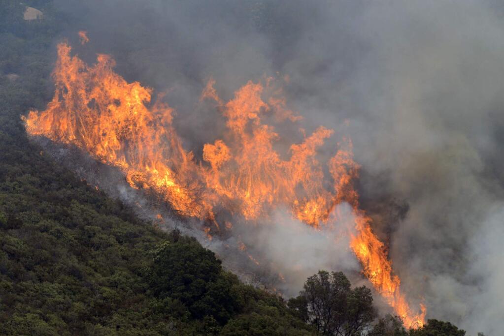 A wildfire burns in the Palo Colorado Canyon in the scenic Big Sur region of California's Central Coast, Monday, July 25, 2016. Fire crews have made some gains against a massive wildfire burning in rugged terrain near the scenic Big Sur region. (David Royal/The Monterey County Herald via AP)