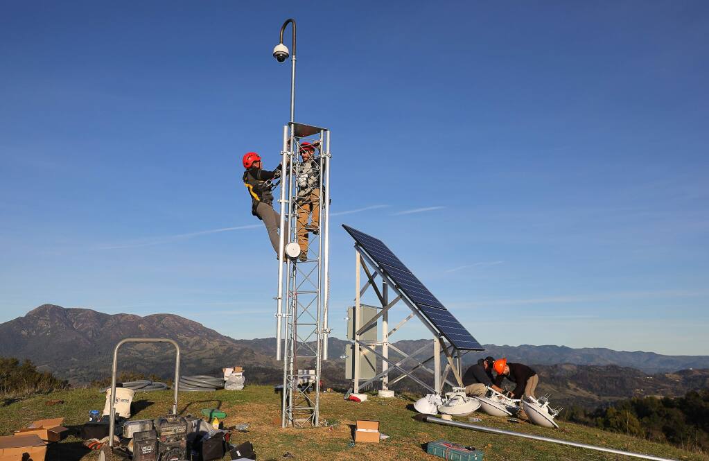 Sara Meyer, left, a field technician from the University of Oregon, and Will Honjas, a field operations coordinator at the Nevada Seismological Laboratory, install an Alert Wildfire camera onto a tower at Pepperwood Preserve, near Santa Rosa, on Tuesday, January 22, 2019. (Christopher Chung/ The Press Democrat)