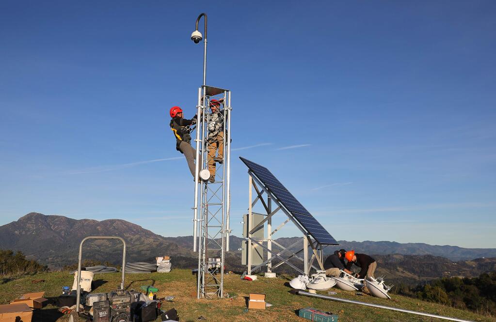 Sara Meyer, left, a field technician from the University of Oregon, and Will Honjas, a field operations coordinator at the Nevada Seismological Laboratory, install an Alert Wildfire camera onto a tower at Pepperwood Preserve, near Santa Rosa, on Tuesday, Jan. 22, 2019. (Christopher Chung / The Press Democrat, 2019)