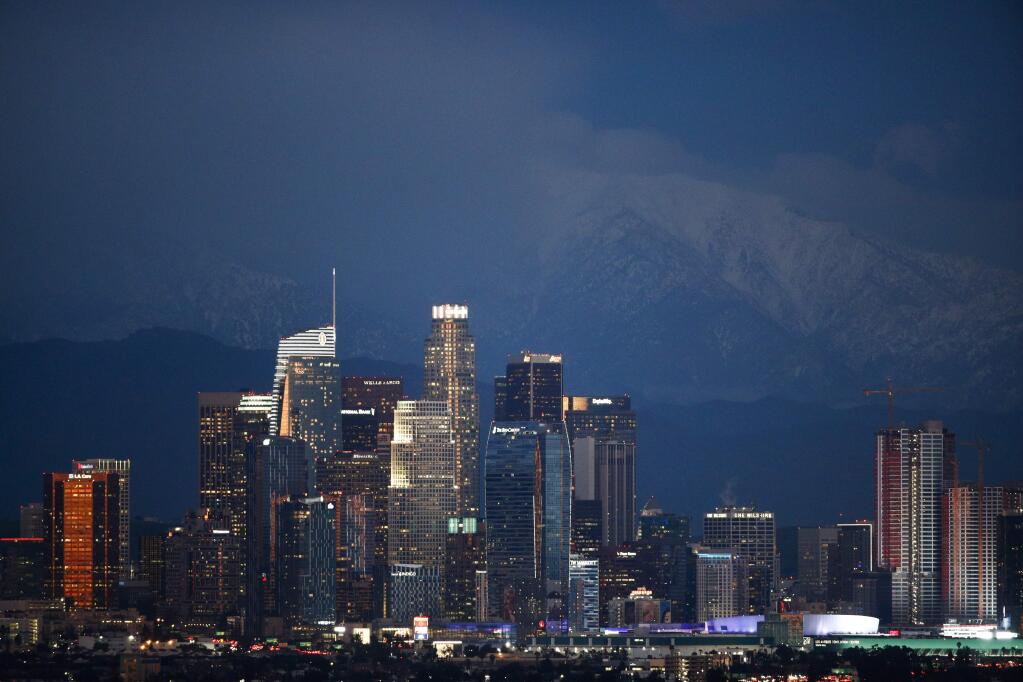 Snow-capped mountains are seen behind the Los Angeles' downtown skyline at dusk Thursday, Feb. 21, 2019, in Los Angeles. (AP Photo/Jae C. Hong)