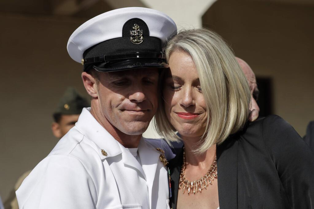 Navy Special Operations Chief Edward Gallagher, left, and his wife, Andrea Gallagher hug after leaving a military court on Naval Base San Diego, Tuesday, July 2, 2019, in San Diego. A military jury acquitted the decorated Navy SEAL Tuesday of murder in the killing of a wounded Islamic State captive under his care in Iraq in 2017. (AP Photo/Gregory Bull)
