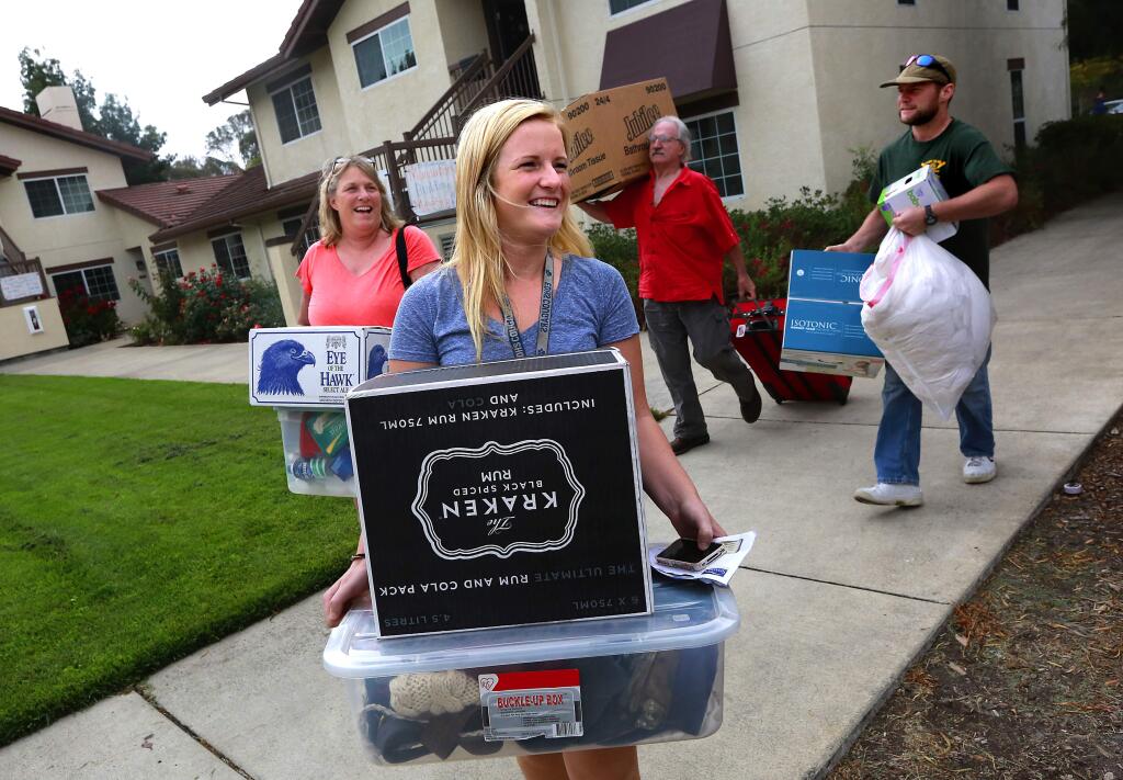 Freshman Josephine Cade of Placerville, looks for her new home with the help of mother Rose, left, dad Jim and brother Max during Move-In Weekend for Sonoma State University students on Saturday, Aug. 16, 2014. (JOHN BURGESS/ PD)