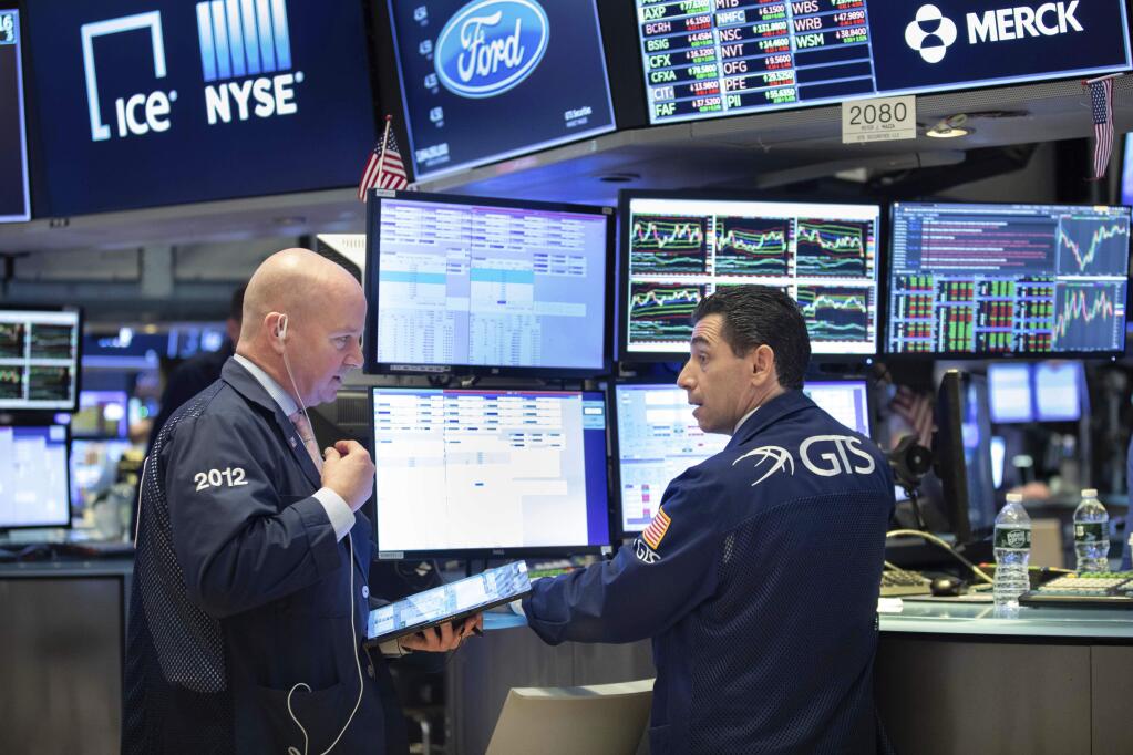This photo provided by the New York Stock Exchange shows trader Patrick Casey, left, and specialist Peter Mazza as they work on the trading floor on Friday, March 20, 2020. Stocks turned lower Friday after New York became the latest major state to mandate nearly all workers stay home to limit the spread of the new coronavirus. (Nicole Pereira/NYSE via AP)
