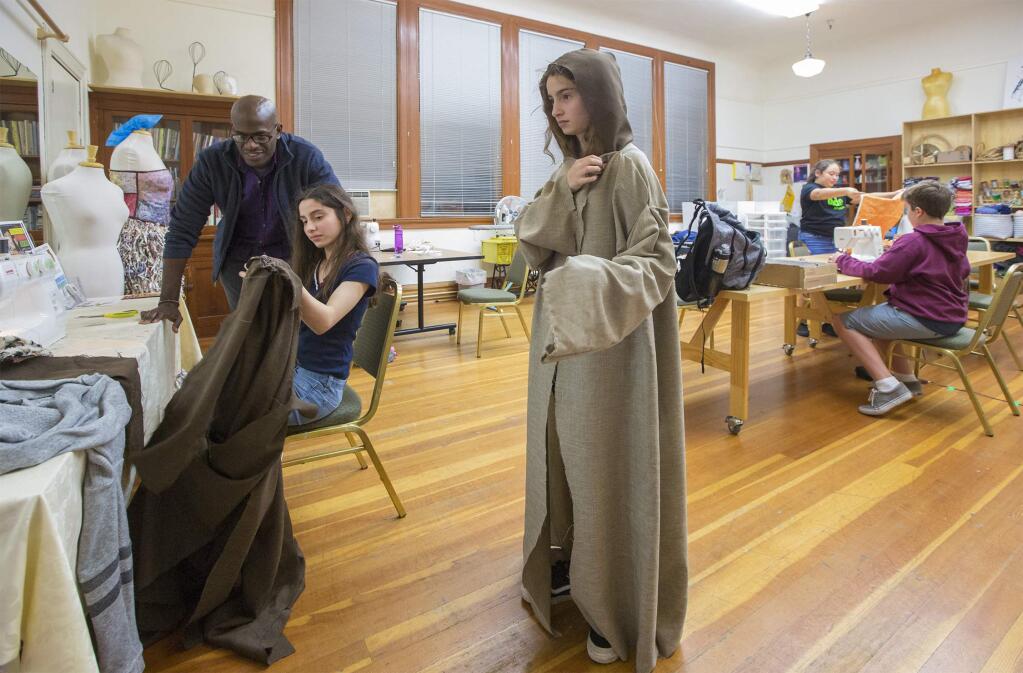 Victoria Hernandez-Padilla checks herself in the mirror to decide how to work the collar on her Jedi robe. Providing a singular level of enthusiasm, Altimira Middle School teacher Bridget Paul has managed to combine a rigorous English curriculum with a love of Star Wars. The Fiber Arts studio under the directorship of Eric Jackson, at the Sonoma Community Center opened its doors and supplied sewing machines for the students to work on their projects on Tuesday, Nov. 27. (Photo by Robbi Pengelly/Index-Tribune)