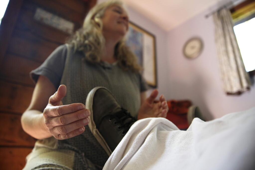 -Pam Rowen-Herzog, a spiritual midwife, treats Jeremiah Becker, 12, at her home office in Cotati.
