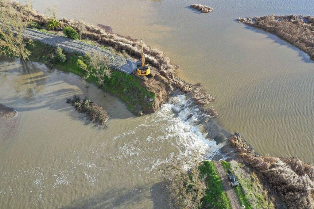 Ghilotti Construction Company crew fills a levee breach with tons of rock near State Route 37 during the mid-February rains that flooded the highway. (Photo courtesy of Ghilotti Construction Company)