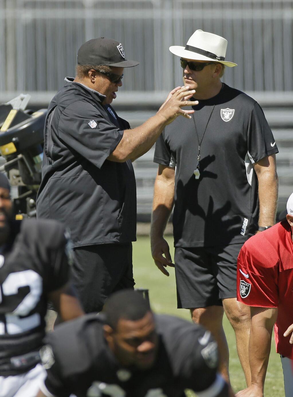 Oakland Raiders general manager Reggie McKenzie, left, talks with head coach Jack Del Rio, right, during their football training camp Monday, Aug. 3, 2015, in Napa, Calif. (AP Photo/Eric Risberg)