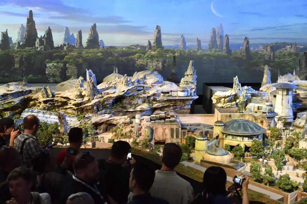 Members of the media get their first look at a 50-foot, detailed model of 'Star Wars' land during a media preview for Disney's D23 Expo in Anaheim, Calf., on Thursday, July 13, 2017. (Jeff Gritchen/The Orange County Register via AP)