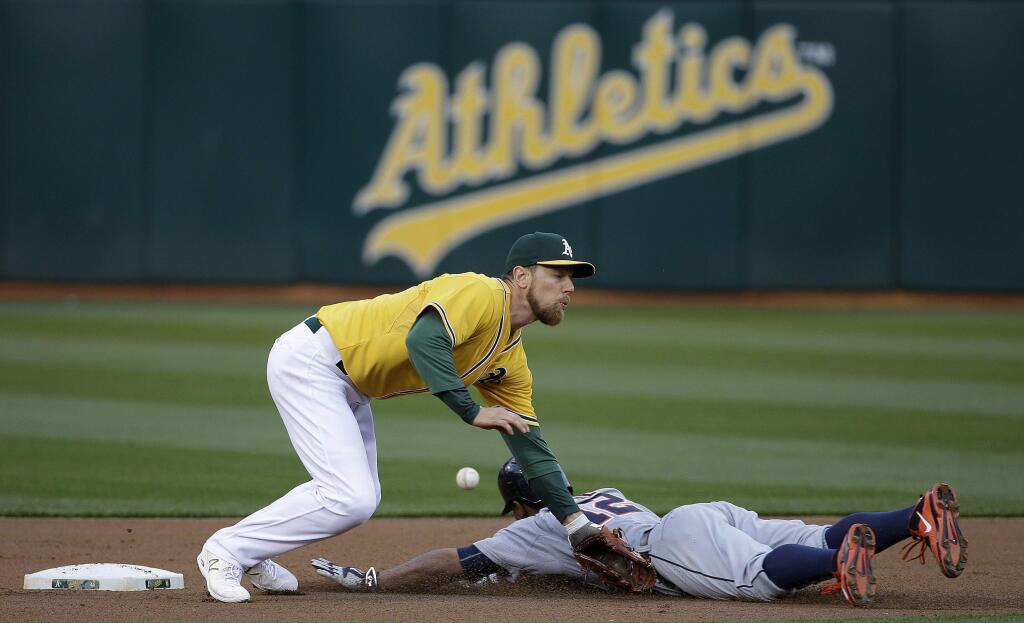 Detroit Tigers' Anthony Gose, bottom, steals second base under Oakland Athletics second baseman Ben Zobrist during the first inning of a baseball game in Oakland, Calif., Tuesday, May 26, 2015. (AP Photo/Jeff Chiu)