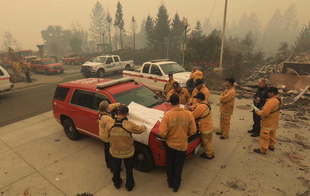 At Santa Rosa's fire Station 5, destroyed by the Tubbs fire, Santa Rosa, Cal Fire and Santa Clara battalion chiefs formulate their plan of attack on the Tubbs fire in Santa Rosa in Fountaingrove. (Kent Porter / Press Democrat) 2017