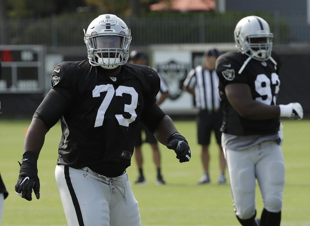 The Oakland Raiders' Maurice Hurst, left, warms up during practice in Napa on Wednesday, Aug. 1, 2018. (AP Photo/Jeff Chiu)