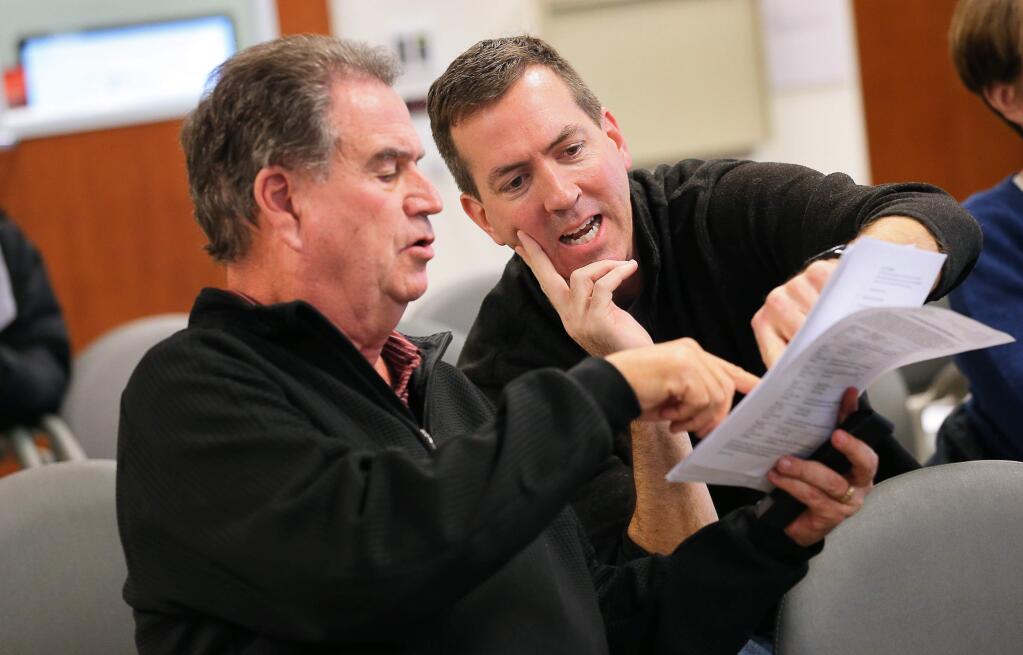 Richard Coombs, left, and Mike Wall discuss the drawing of voting district maps while attending a special Windsor Town Council meeting on Monday, February 25, 2019. (Christopher Chung/ The Press Democrat)