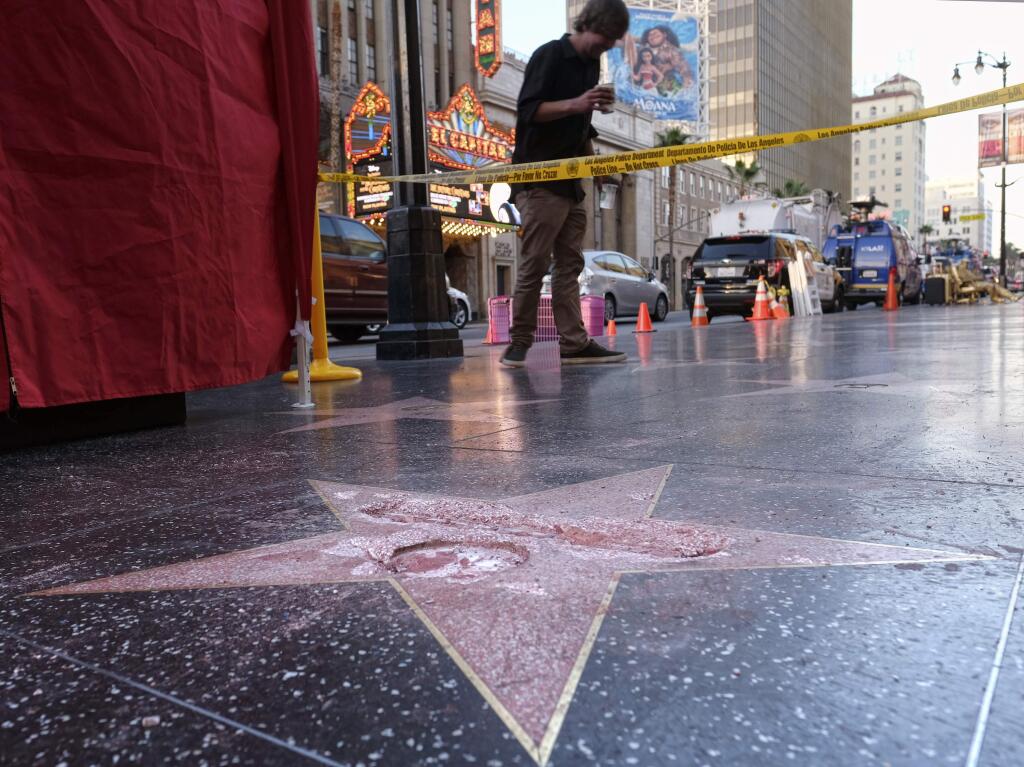 A man stands near a cordoned off area surrounding the vandalized star for Republican presidential candidate Donald Trump on the Hollywood Walk of Fame, Wednesday, Oct. 26, 2016, in Los Angeles. Det. Meghan Aguilar said investigators were called to the scene before dawn Wednesday following reports that Trump's star was destroyed by blows from a hammer. (AP Photo/Richard Vogel)