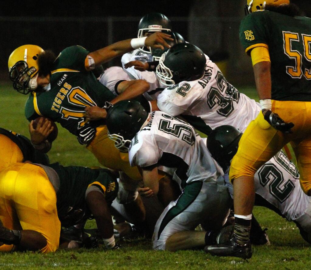 Bill Hoban/Index-TribuneA group of Sonoma defenders, including Nick Fantozzi (No. 51, bottom left), Seth August (No. 32, middle) and Mark Shipston (No. 20, right), bring down a Tiger runner during the Dragons' nonleague loss to Fremont of Oakland Friday night at Arnold Field.
