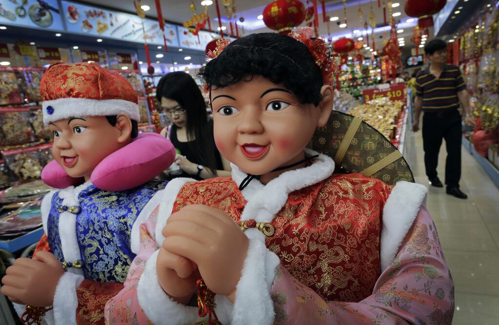 Dolls dressed in traditional Chinese costume welcome customers at a store selling Chinese New Year decorations, Wednesday, Feb. 18, 2015 in Singapore. This year marks the Year of the Sheep in the Chinese Lunar calendar. (AP Photo/Wong Maye-E)