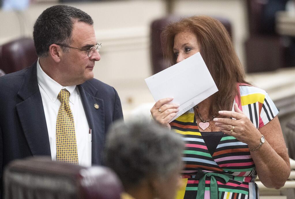 Rep. Terri Collins, right, chats with Rep. Chris Pringle on the house floor at the Alabama Statehouse in Montgomery, Ala., on Tuesday May 14, 2019. Alabama lawmakers are expected to vote on a proposal to outlaw almost all abortions in the state, a hardline measure that has splintered Republicans over its lack of an exception for pregnancies resulting from rape or incest. Rep. Collins is the sponsor of the bill. (Mickey Welsh/Montgomery Advertiser via AP)
