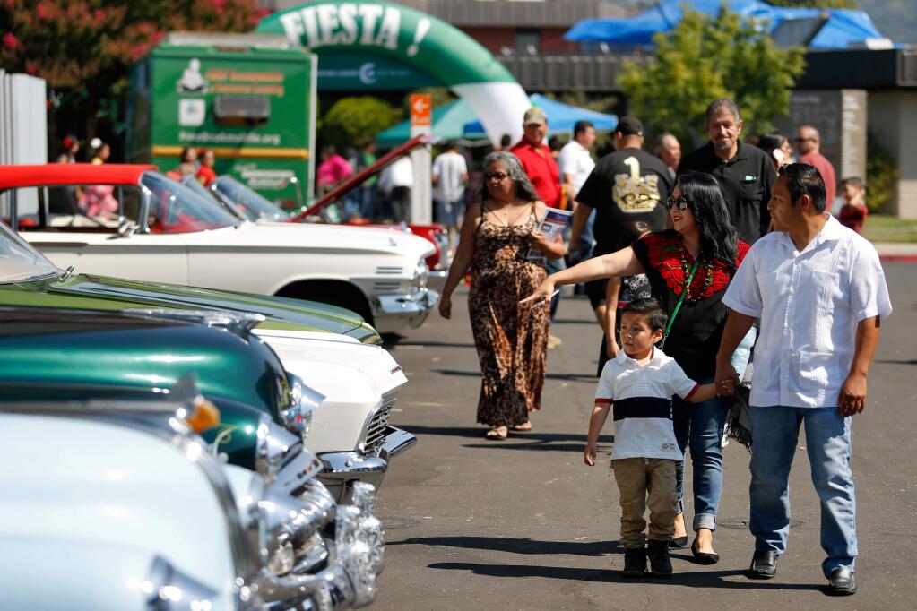 The Manzanares family, from right, Abel, Graciela, and Isaac, 5, admire the lowriders on display during Fiesta de Independencia at Luther Burbank Center for the Arts in Santa Rosa, California, on Sunday, September 17, 2017. (Alvin Jornada / The Press Democrat)