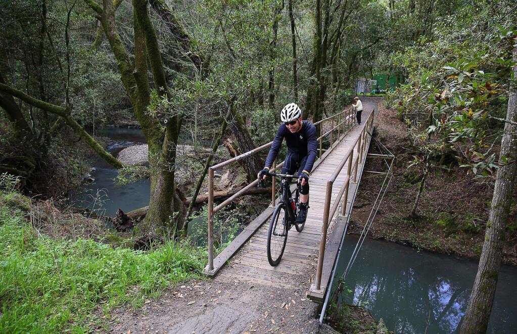Cyclist Jay Abraham crosses a bridge from the trail off of Channel Drive towards Stone Bridge Road in the Oakmont area of Santa Rosa on Thursday, March 16, 2017. (Christopher Chung/ The Press Democrat)