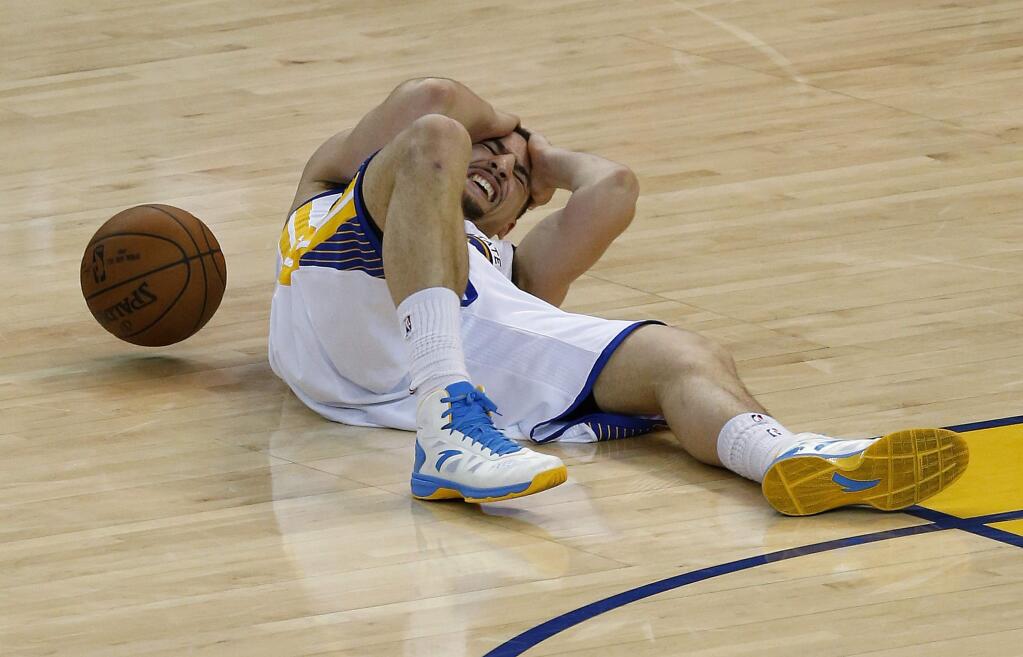This May 27, 2015, file photo shows Golden State Warriors guard Klay Thompson on the court after being injured during the second half of Game 5 of the NBA basketball Western Conference finals against the Houston Rockets in Oakland, Calif. When NBA union chief Michele Roberts watched Stephen Curry return to a game after his head slammed against the floor and he walked woozily to the locker room, she immediately boned up on the league's concussion protocols. Two nights later, when Curry's Golden State teammate Klay Thompson was cleared to return after being kneed in the head only to later be diagnosed with a concussion, her reaction was much stronger. 'It mortified me,' she said. (AP Photo/Tony Avelar, File)
