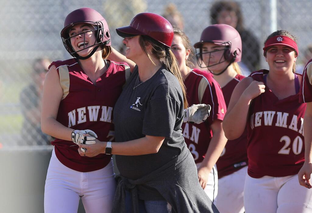 Cardinal Newman's Caroline Courier, left, is congratulated by assistant coach Holly Brown after hitting a home run against Montgomery, in Santa Rosa on Thursday, March 29, 2018. (Christopher Chung/ The Press Democrat)