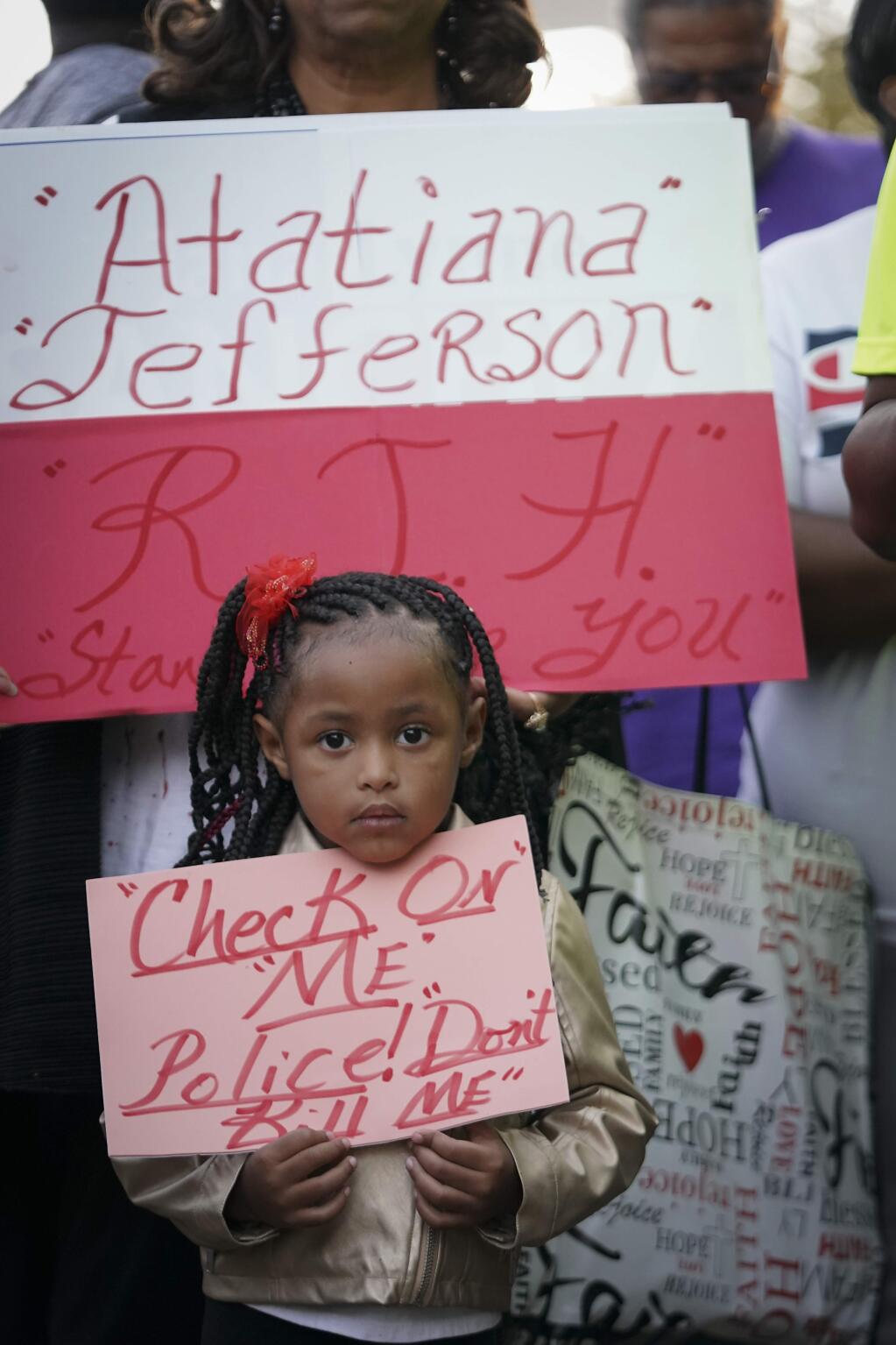 Trinity Ford, 4, joins the crowd gathered during a community vigil for Atatiana Jefferson on Sunday, Oct. 13, 2019, in Fort Worth, Texas. A white police officer who killed the black woman inside her Texas home while responding to a neighbor's call about an open front door 'didn't have time to perceive a threat' before he opened fire, an attorney for Jefferson's family said. (Smiley N. Pool/The Dallas Morning News via AP)