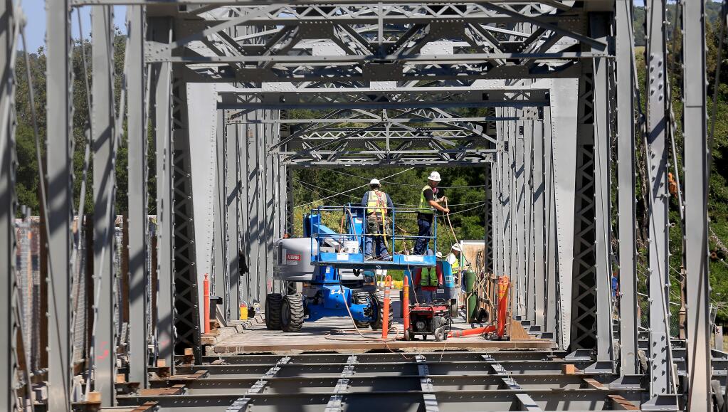 Workers prepare to wrap up for the day as they continue work on the Healdsburg Memorial Bridge, Monday April 20, 2015. (Kent Porter / Press Democrat) 2015