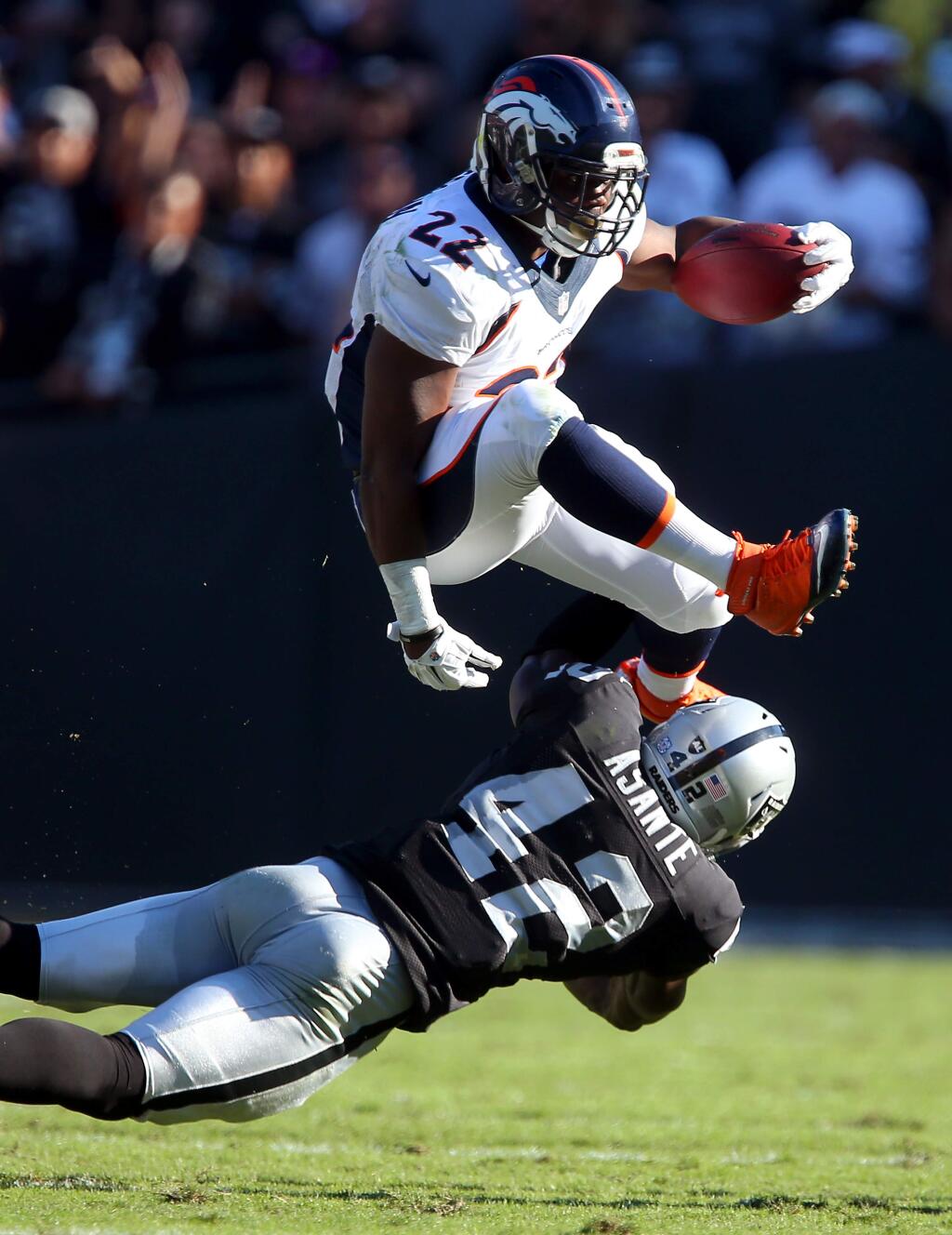 Denver Broncos running back C.J. Anderson hurdles Oakland Raiders safety Larry Asante for a first down during the second quarter of their game in Oakland on Sunday, November 9, 2014. The Broncos defeated the Raiders 41-17.(Christopher Chung/ The Press Democrat)
