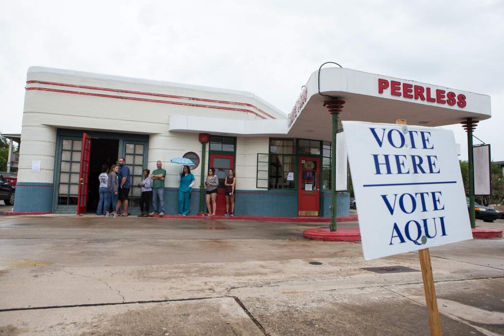 Voters stand in line at Peerless Cleaners in Corpus Christi, Texas to cast their ballots on Election Day, Tuesday, Nov. 8, 2016.(Courtney Sacco/Corpus Christi Caller-Times via AP)