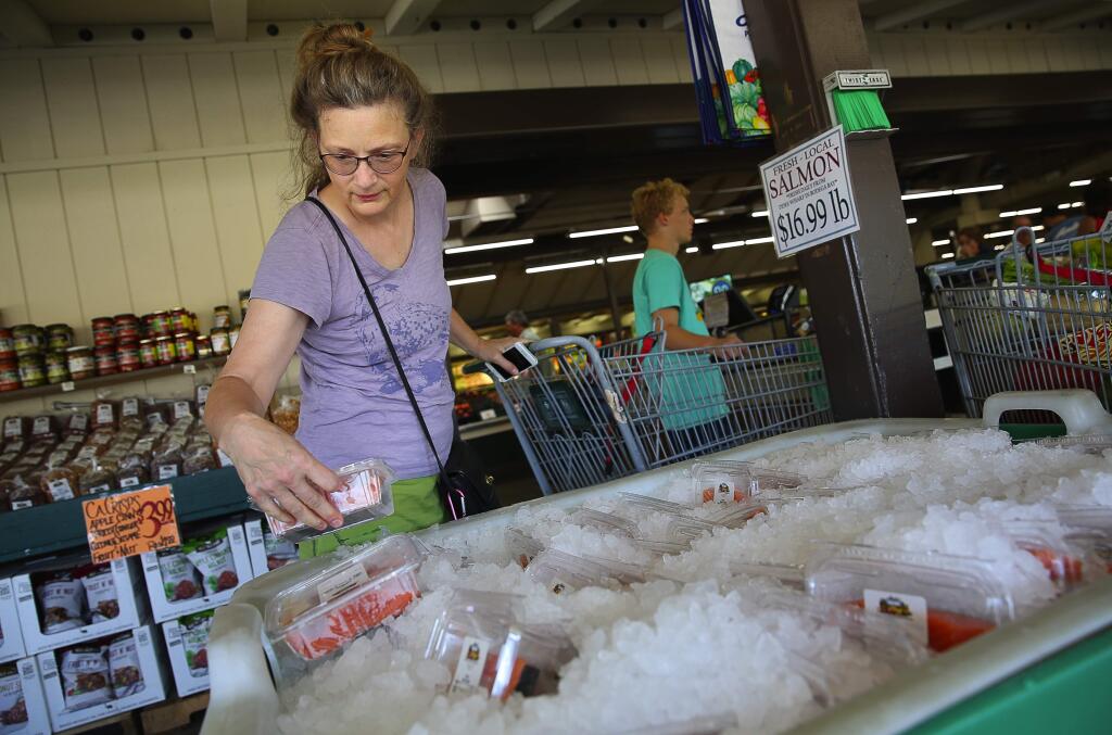 Penny Horobin selects a couple fresh locally caught salmon at Andy's Produce Market, in Sebastopol, on Monday, September 21, 2015. (Christopher Chung/ The Press Democrat)
