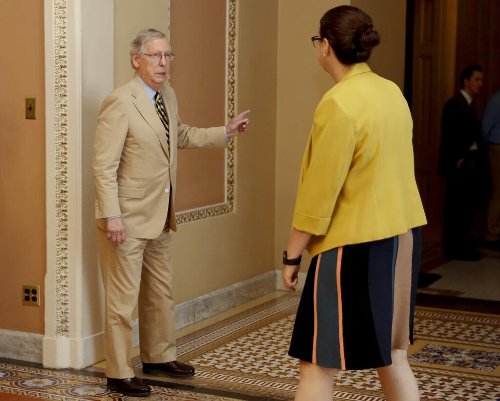 Senate Majority Leader Mitch McConnell of Ky., talks with Secretary for the Majority Laura Dove, as he walks to his office on Capitol Hill in Washington, Monday, June 26, 2017. Senate Republicans unveil a revised health care bill in hopes of securing support from wavering GOP lawmakers, including one who calls the drive to whip his party's bill through the Senate this week 'a little offensive.' (AP Photo/Carolyn Kaster)