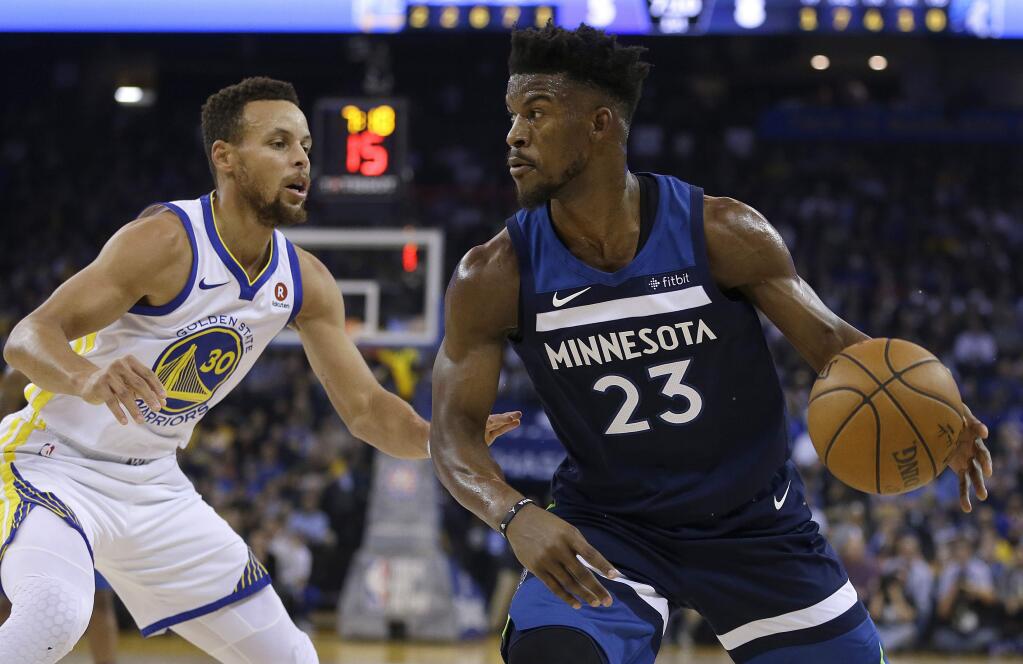 The Minnesota Timberwolves' Jimmy Butler, right, drives the ball against the Golden State Warriors' Stephen Curry during the first half Wednesday, Nov. 8, 2017, in Oakland. (AP Photo/Ben Margot)
