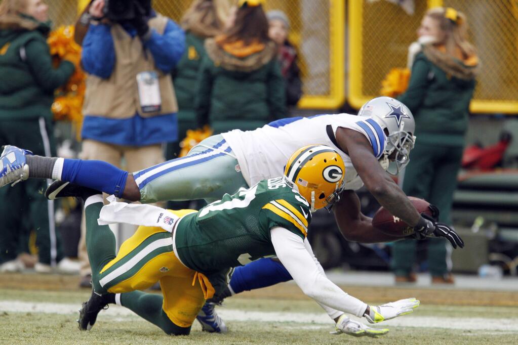 In this Jan. 11, 2015, file photo, Dallas Cowboys wide receiver Dez Bryant, top, grabs a pass against Green Bay Packers cornerback Sam Shields during the second half of an NFL divisional playoff football game in Green Bay, Wis. Bryant still gets stopped all the time by people who are sure the refs blew the replay on the Dallas receiver's famous catch that wasn't. (AP Photo/Matt Ludtke, File)