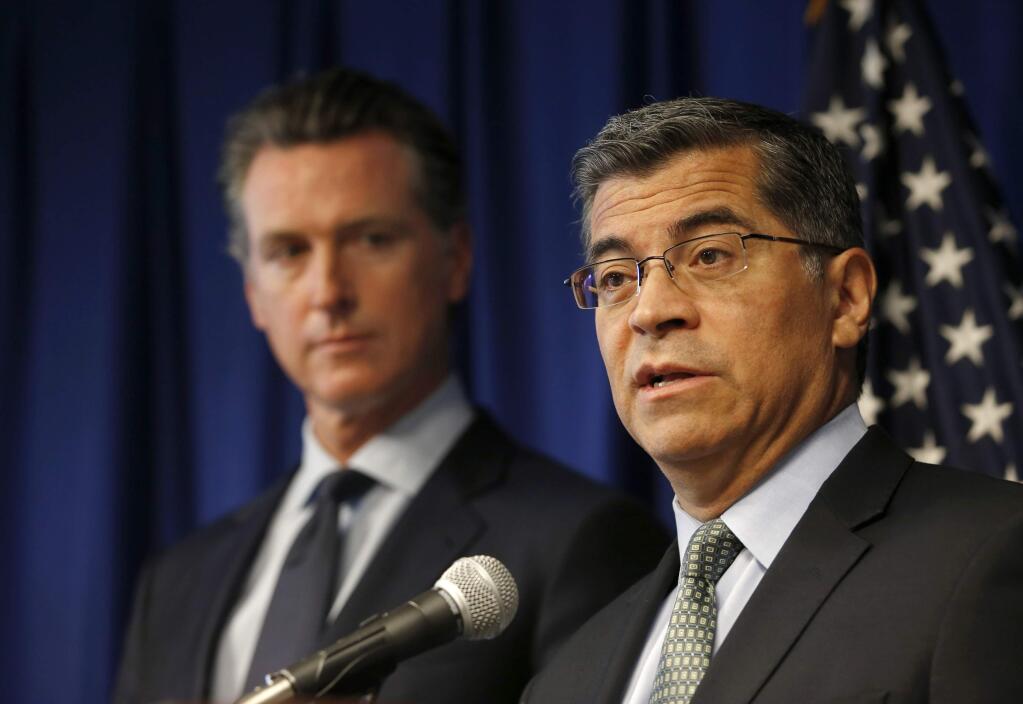 FILE - In this Sept. 18, 2019, file photo California Attorney General Xavier Becerra, right, flanked by Gov. Gavin Newsom, speaks during a news conference in Sacramento, Calif. California attorney general says he has been investigating Facebook's privacy practices since 2018. Becerra offered few details about the probe and said he was disclosing it only because his office was making a public court filing to force Facebook to answer its subpoenas, which Becerra said Facebook has failed to respond adequately do. (AP Photo/Rich Pedroncelli, File)