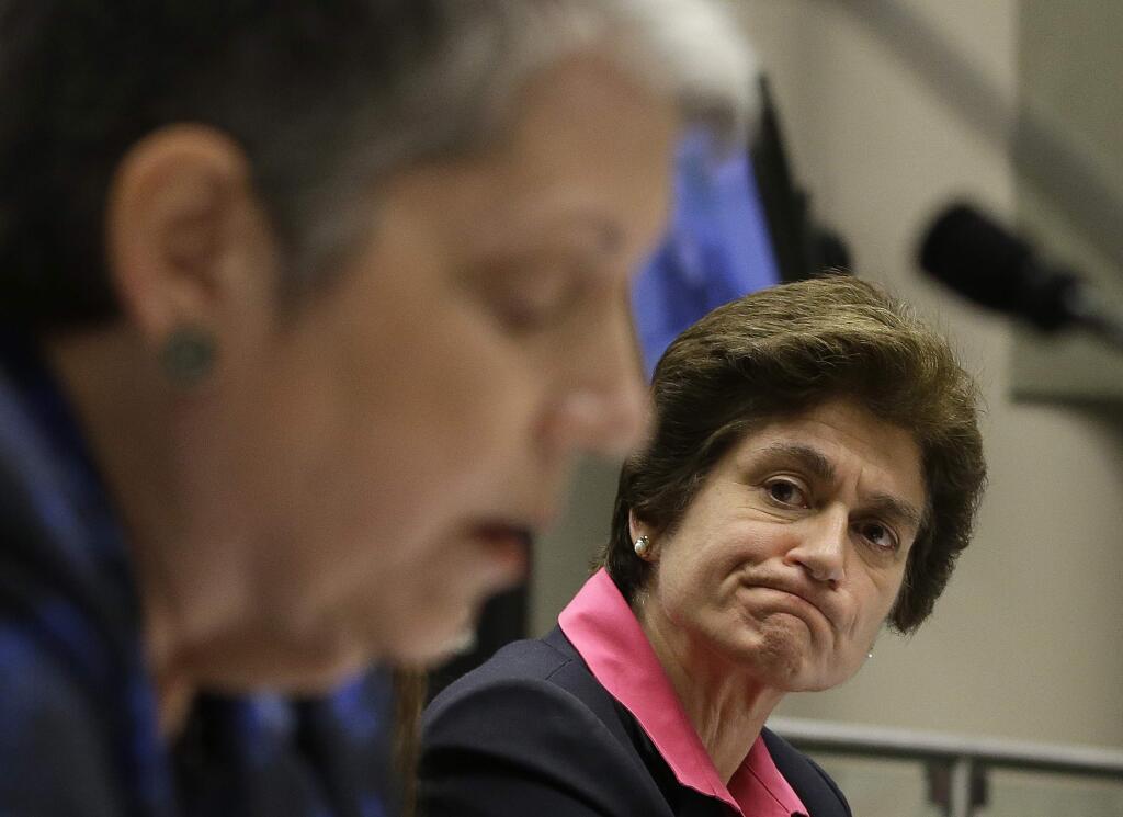 FILE - In this May 2, 2017, file photo, State Auditor Elaine Howle, right, looks over at University of California President Jane Napolitano reading her statement concerning the audit conducted by Howle's office, during a hearing of the Joint Legislative Audit Committee in Sacramento, Calif. State auditors are faulting the University of California for not addressing sexual misconduct complaints on time and not disciplining faculty swiftly. (AP Photo/Rich Pedroncelli, File)