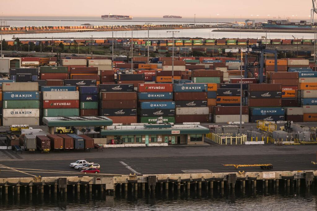 A tiny boat pulls up to a container ship being loaded at the Port of Seattle, Monday, Feb. 9, 2015, in Seattle. West Coast seaports fully reopened Monday after two days during which no ships were unloaded amid a labor dispute between dockworkers and their employers. The two sides are negotiating a new contract, and bargaining-table tensions have spilled over to the waterfront, where cargo is moving far slower than normal through ports that handle about one-quarter of the nation's international trade nearly $1 trillion annually. (AP Photo/Elaine Thompson)