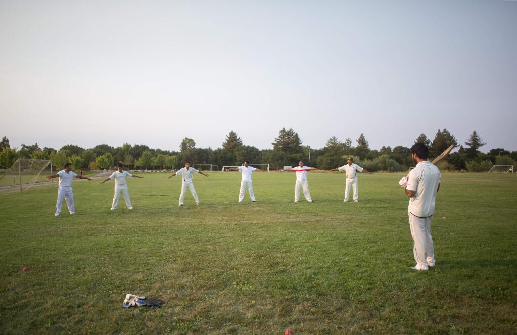 Members of the Sonoma Gullies cricket team warmup before practice at A Place to Play park in Santa Rosa, Calif. Friday, July 31, 2015. The Gullies are looking for a permanent place to call home as they are currently practicing along a walkway at the park.
