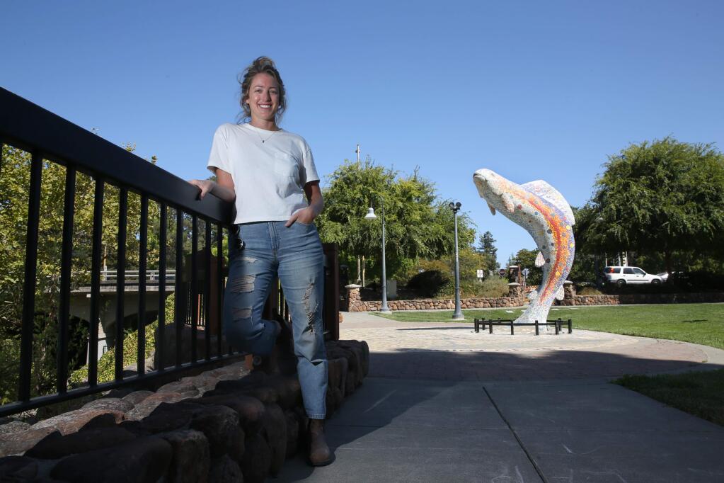 ArtStart lead artist Angelina Duckett stands nears the mosaic fish sculpture that she helped to repair in Prince Gateway Park in Santa Rosa, California on Thursday, August 29, 2019. (BETH SCHLANKER/The Press Democrat)