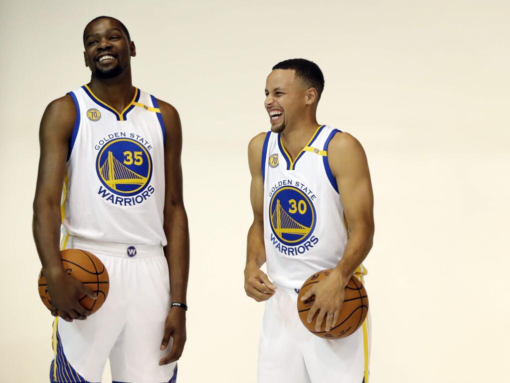 Golden State Warriors' Kevin Durant, left, and Stephen Curry joke as they pose for photos during NBA basketball media day Monday, Sept. 26, 2016, in Oakland, Calif. (AP Photo/Marcio Jose Sanchez)